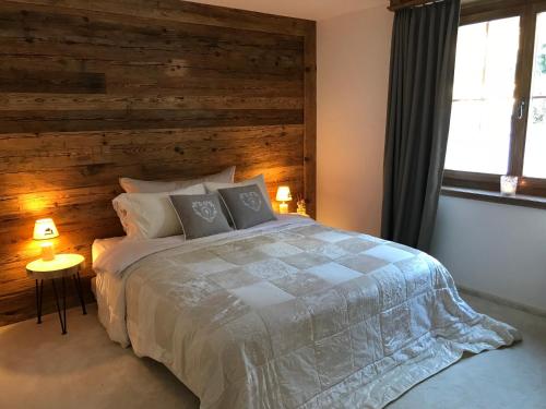 a bedroom with a large bed with a wooden wall at Genuss in den Bergen! in Klosters Serneus
