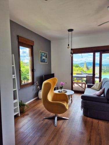 a living room with a yellow chair and a couch at Sutla House in Senkovec