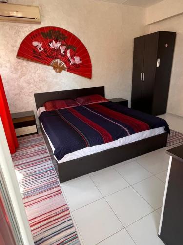 a bedroom with a large bed with a red headboard at Helga Apartment in Obzor