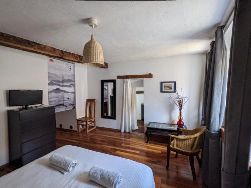a bedroom with a bed and a living room at Chambres d'hôtes Les Chatougoulis in Les Bordes-sur-Lez