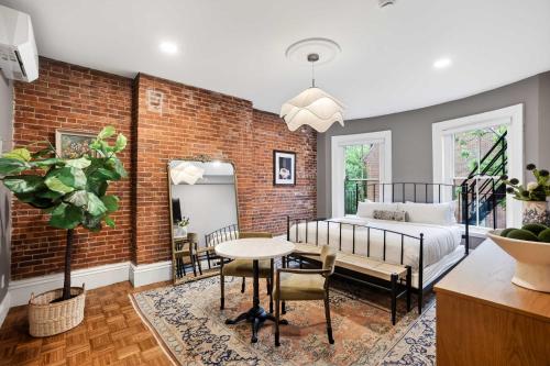 a living room with a bed and a brick wall at The Concord Hotel in Boston