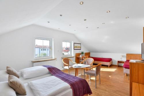 a bedroom with a bed and a table and chairs at Hotel Hecht Garni in Ingolstadt