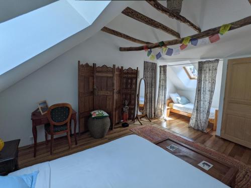 a bedroom with a bed and a desk and a chair at Chambres d'hôtes Les Chatougoulis in Les Bordes-sur-Lez