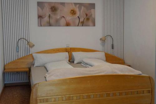 a bedroom with a wooden bed with a painting on the wall at Ferienwohnung Salvenblick in Söll