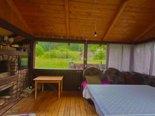 a room with a bed and a table and a fireplace at Карпатський затишок in Verkhovyna