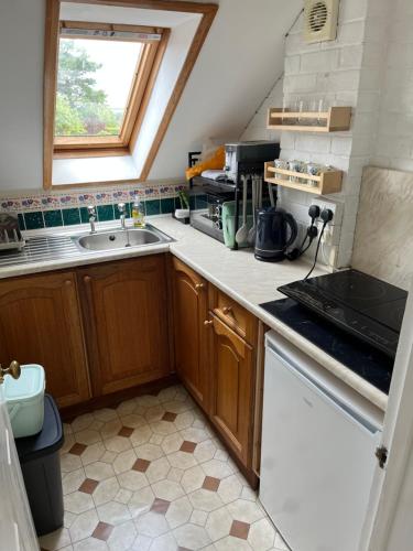a small kitchen with a sink and a window at Quiet Annexe in Oundle in Oundle
