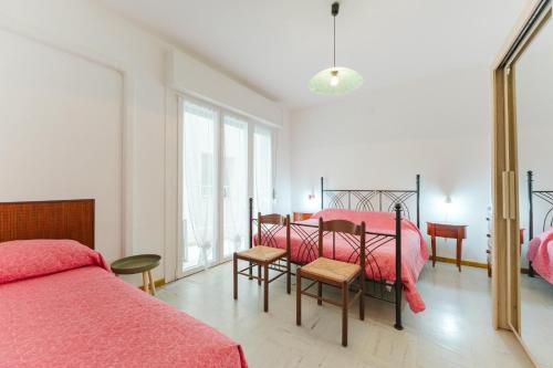 a bedroom with two beds and a window at Anna Flat - 2 minuti dalla spiaggia in Lido di Jesolo