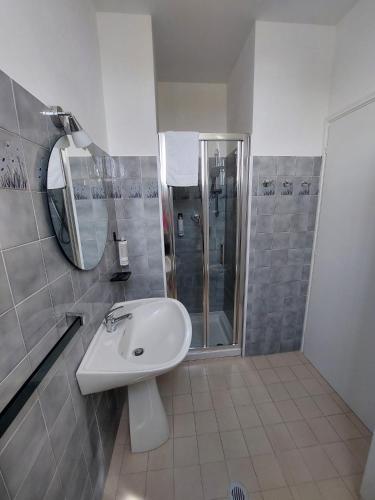 a white bathroom with a sink and a shower at Monolocale 100metri dal mare in Fano