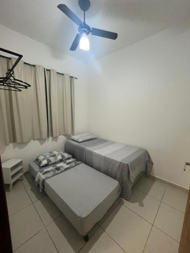 a bedroom with two beds and a ceiling fan at Casa de praia in Marechal Deodoro