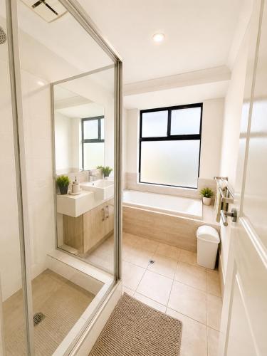 a bathroom with a shower and a toilet and a sink at Modern oasis in Perth