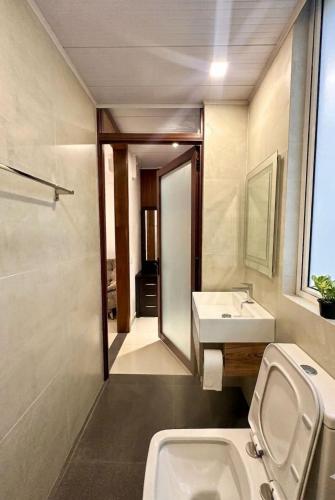 a bathroom with a sink and a toilet and a mirror at Easy Stay in Kandy