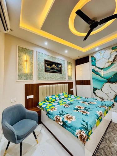 a bedroom with a bed and a blue chair at THE MOONLIGHT STUDIo in Ghaziabad