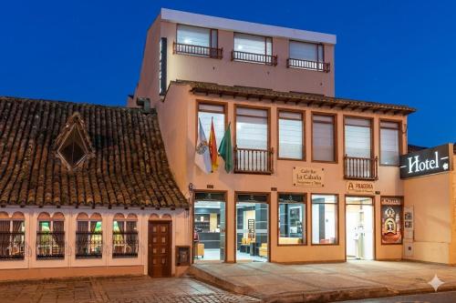 a tall building with windows and a building at Hotel Plaza Muisca in Tunja