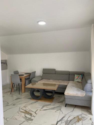 a living room with a couch and a table and chairs at Apartman Žepče in Žepče