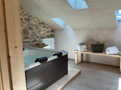 eine Badewanne in einem Raum mit einer Steinwand in der Unterkunft Borgo Poli in Fanano