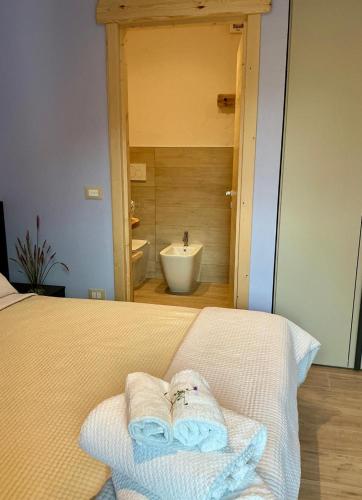 ein Schlafzimmer mit einem Bett mit Handtüchern und einem Waschbecken in der Unterkunft Borgo Poli in Fanano