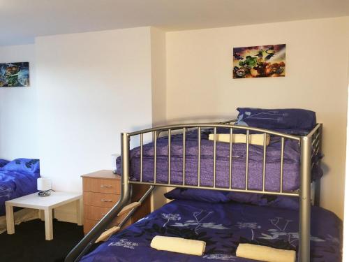 Un dormitorio con una litera con sábanas moradas en Park Drive TownHouse, en Mánchester
