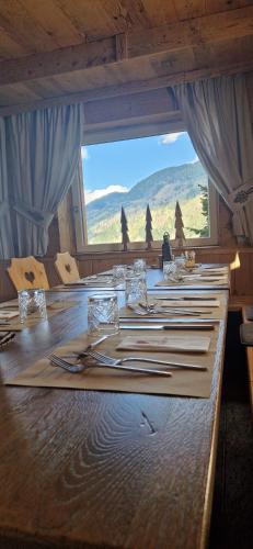 a long wooden table with a view of a mountain at Hotel Almhof in San Candido