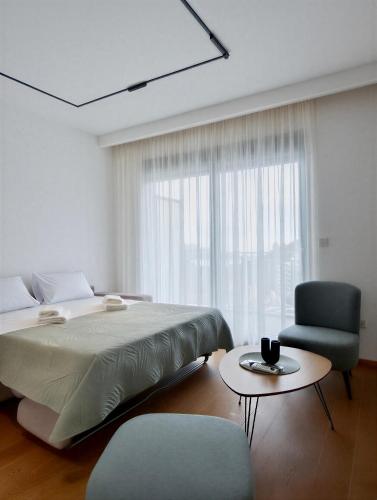 a bedroom with a bed and a chair and a table at Azzurro Vista in Budva