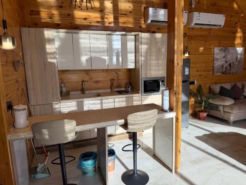 a kitchen with a counter and chairs in a room at أكواخ كيفاء الريفية in Tabuk