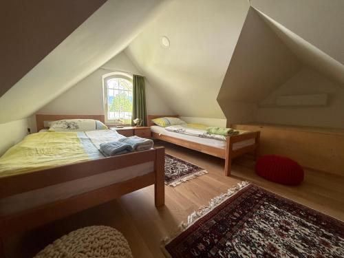 a attic bedroom with two beds and a window at Vila Katja in Bled
