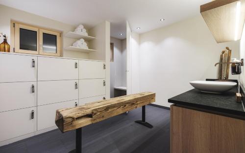 a kitchen with white cabinets and a wooden bench at Hotel Landhaus in Münster