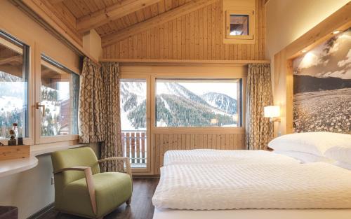 a bedroom with two beds and a chair and a window at Hotel Landhaus in Münster