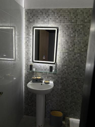 a bathroom with a white sink and a mirror at Complex riad tanger in Hajreien