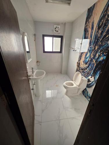 a bathroom with a toilet and a sink at فندق مواسم الخير in Al ‘Azīzīyah
