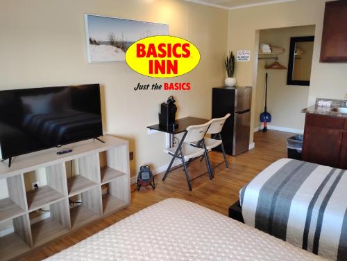 a bedroom with a bed and a flat screen tv at BASICS Inn in Truro