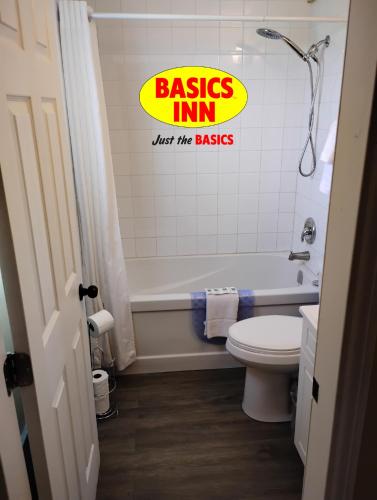 a bathroom with a tub and a toilet and a sign at BASICS Inn in Truro