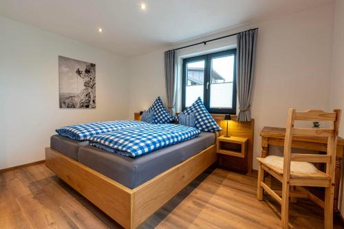 a bedroom with a bed and a desk and a chair at Ferienwohnung Stuibock in Fischen