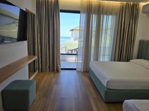 a hotel room with a bed and a view of the ocean at Rei Hotel in Borsh