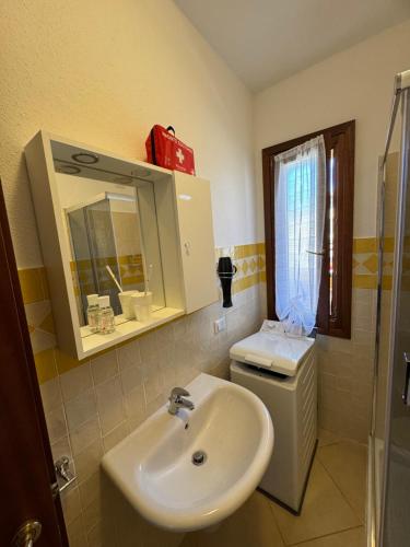 a bathroom with a sink and a toilet and a mirror at Carpa House in Valledoria