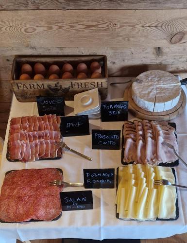 a table topped with different types of meats and cheese at Hotel Almhof in San Candido