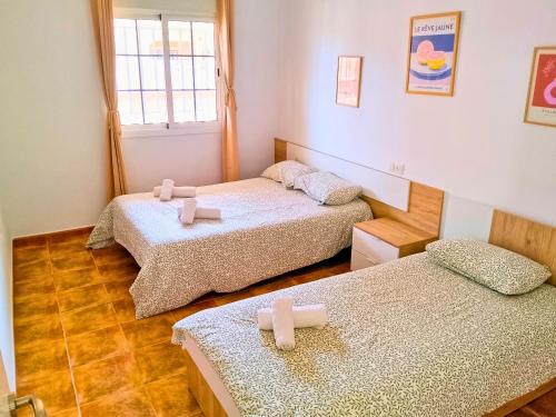 two beds in a room with towels on them at Horizon Isla Tabarca in El Cabo de Gata