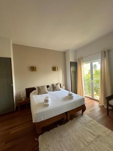 a bedroom with a large bed and a large window at Wonderful Villa Cala Tarida in Sant Josep de sa Talaia