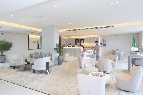 a man and a woman standing in a waiting room at Bawabat Alnakhil For Hotel Apartments in Riyadh
