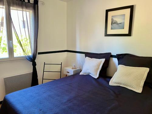 a bedroom with a blue bed and a window at Villa Câline chambres d'hôtes in Vesseaux