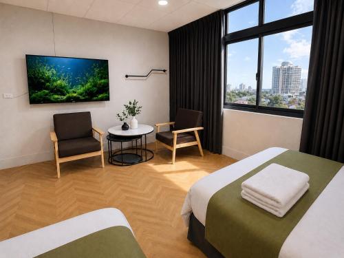 a hotel room with a bed and a table and a tv at 礁溪希沐湯泉民宿 2026年7月全新面貌登場 價格優惠中 in Jiaoxi