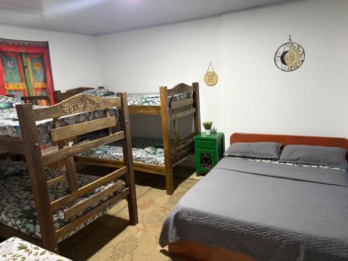 a bedroom with two beds and a clock on the wall at Playa Zen Rodadero in Rodadero