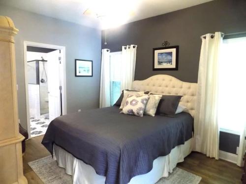 a bedroom with a large bed with a white headboard at The Lantern in Pensacola