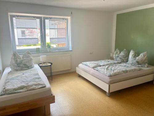 a bedroom with two beds and a window at Ferienwohnung Nähe Autobahn Ruhige Lage für Familien & Monteure in Erolzheim