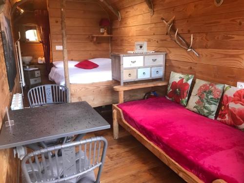 a bedroom with a bed and a table in a cabin at Domaine La Roche Bellin in Descartes
