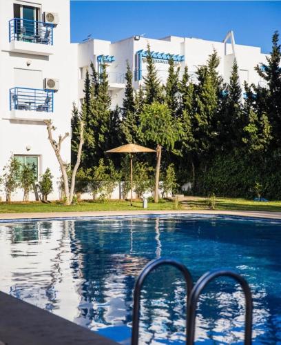 a swimming pool in front of a building at CaboNegro Appart Resort, Piscine, Plage, Détente in Cabo Negro