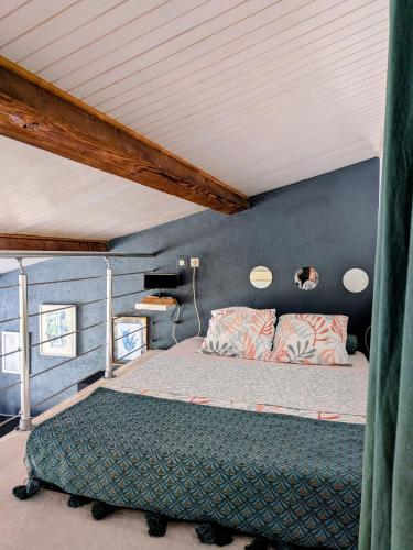 a bedroom with a bed and a blue wall at Tiny house - Drap, France in Drap