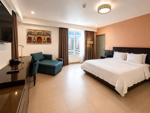 a hotel room with a bed and a chair at The District Hotel in Panama City
