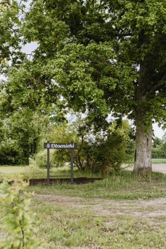 a sign in the grass next to a tree at Obsenieki - moderna lauku sēta in Stalidzāni