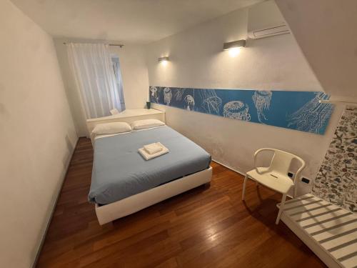 a small bedroom with a bed and a chair at Mare Mosso 2 in Manarola