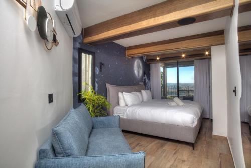 a bedroom with a bed and a couch and a chair at Nof Yareach - נוף ירח in Safed